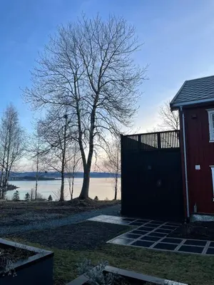 a house with a gate and a tree and water at NerSalberg Farm