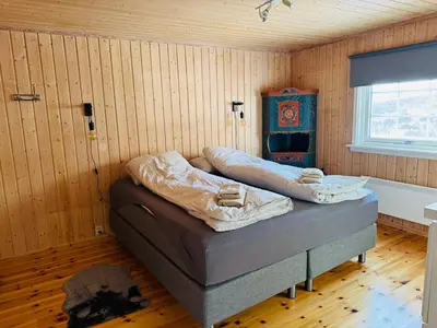 a bedroom with a bed in a room with wooden walls at Cozy cabin in the middle of peaceful surroundings in Geilo