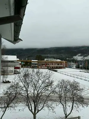 a snow covered parking lot with trees and buildings at Large apartment, in the middle of Gol city center! in Gol