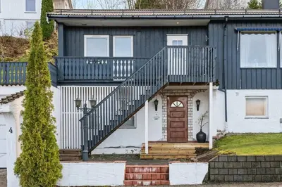 a house with a blue and white house with a staircase at Enebolig med 5 soverom in Lii