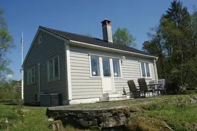 a small house with two chairs in front of it at Charming sea view in Bergen