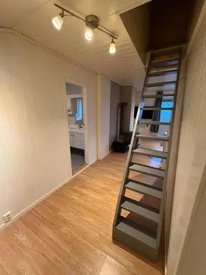 an empty room with a staircase in a house at Charming sea view in Bergen