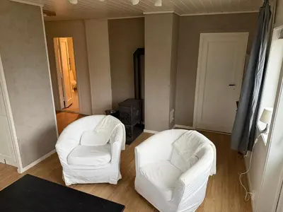 two white chairs sitting in a living room at Charming sea view in Bergen