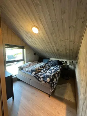 a bed in a small room with a wooden ceiling at Modern cabin in Rauland with Panorama view in Torvetjørn
