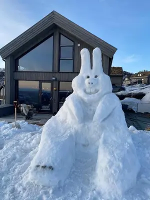 a snowman made out of snow in front of a house at Modern cabin in Rauland with Panorama view in Torvetjørn
