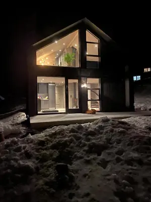 a house is lit up at night in the snow at Modern cabin in Rauland with Panorama view in Torvetjørn