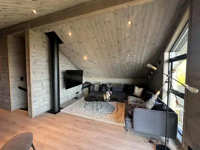 a living room with a couch and a tv at Modern cabin in Rauland with Panorama view in Torvetjørn