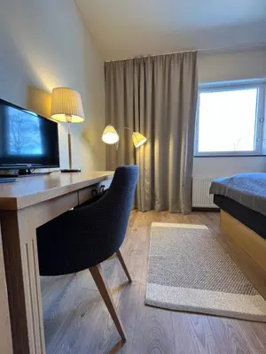 a room with a desk with a television and a chair at Granavolden Hotel & Gjæstgiveri in Gran
