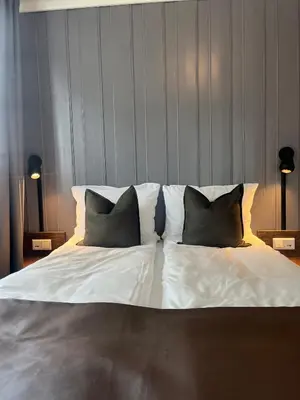 a large white bed with two pillows on it at Granavolden Hotel & Gjæstgiveri in Gran