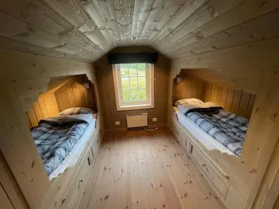 two beds in a log cabin with a window at Modern and cozy cabin near ski slopes in Beitostøl