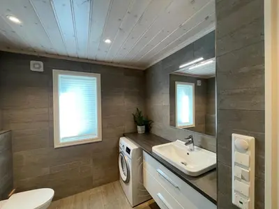 a bathroom with a sink and a washing machine at Modern and cozy cabin near ski slopes in Beitostøl