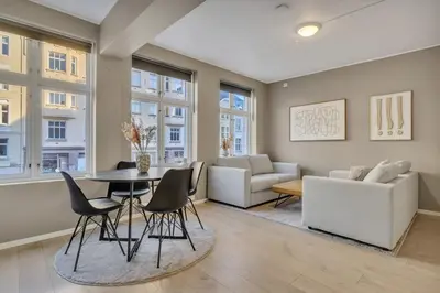 a living room with a table and chairs and a couch at Bryggen Gateway Homes in Bergen