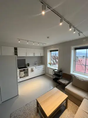 a living room with a couch and a table at Nice and central apartment in Sandviken with sea view in Bergen