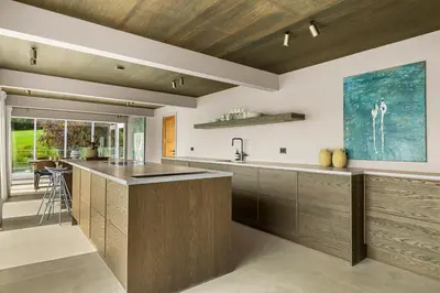 a kitchen with wooden cabinets and a counter top at Villa with pool and panorama - friend trip,company outing in Trondheim