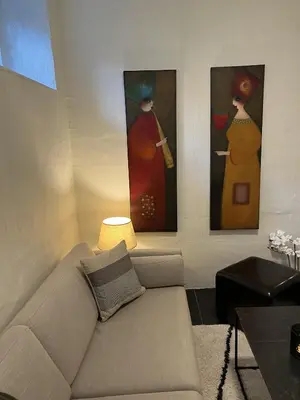 a living room with a couch and three paintings at Apartment in the heart of Bergen in Bergen