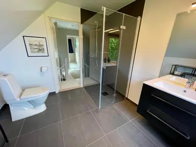 a bathroom with a toilet and a sink and a shower at 5 Bedroom House at Hakallestranda in Sandvik