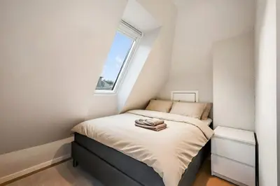 a small bedroom with a bed and a window at Renovated Apartment in Central Area in Bergen