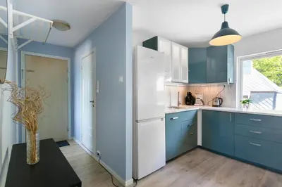 a kitchen with blue cabinets and a white refrigerator at Centrum apartment 1 in Ålesund