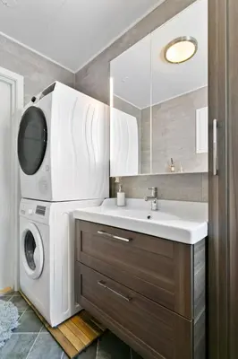 a bathroom with a washing machine and a sink at Centrum apartment 1 in Ålesund