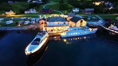 a boat is docked at a marina at night at Davik Fjordparadis