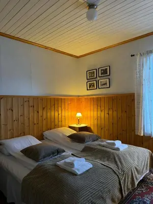 two beds in a bedroom with a lamp on a table at Davik Fjordparadis