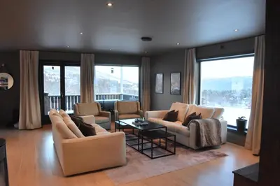 a living room with two couches and a table at luxury home with jacuzzi in Geilo