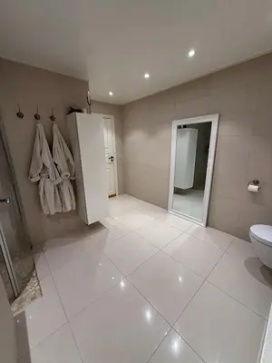 a white bathroom with a toilet and a sink at luxury home with jacuzzi in Geilo