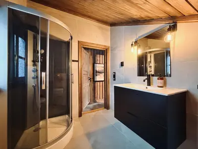 a bathroom with a shower and a sink and a mirror at Stylish cabin near Hemsedal ski resort, 200 m to slopes & lift in Hemsedal