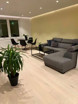 a living room with a couch and a table and chairs at Nordic Apartment near by the city in Bergen
