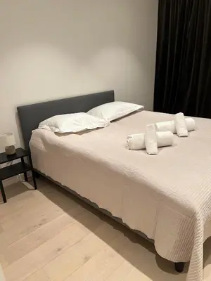 a bed with white sheets and pillows on it at Nordic Apartment near by the city in Bergen
