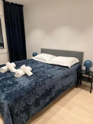 a bedroom with a bed with two towels on it at Nordic Apartment near by the city in Bergen