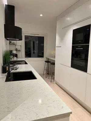 a kitchen with white cabinets and a white counter top at Nordic Apartment near by the city in Bergen