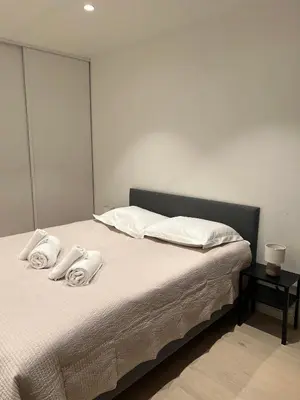 a bedroom with a bed with towels on it at Nordic Apartment near by the city in Bergen