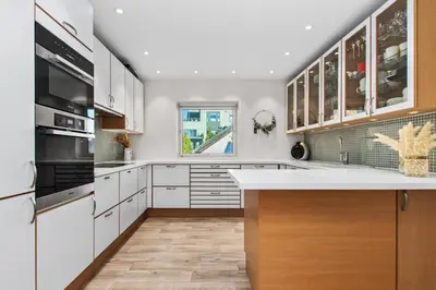 a kitchen with white cabinets and a large window at Konsul Moes Gate 4 in Verdal