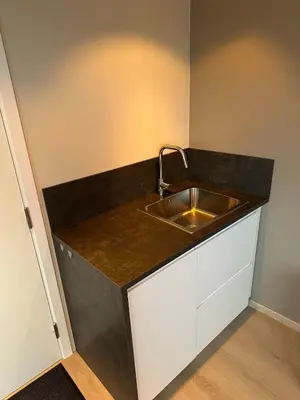 a kitchen with a sink and a counter top at Apartment centrally with garage and terrace in Ålesund