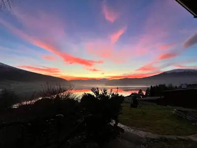 a sunset over a lake with mountains in the background at Innvik Hytte Anna in Stryn