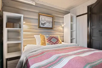 a bedroom with a bed and a wooden wall at Trysilfjell nord 590 by Vacation Trysil in Trysil