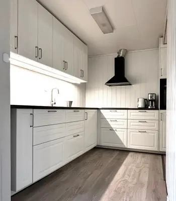 a white kitchen with white cabinets and a sink at Apartment centrally located in Bud in Bud