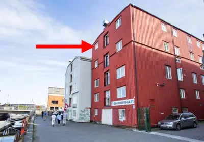 a red arrow pointing to a red building at Riverside studioapartment 100m from trainstation! in Trondheim