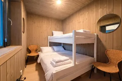 a small room with a bunk bed and two chairs at Modern ski-in-ski-out apartment in Hemsedal in Hemsedal