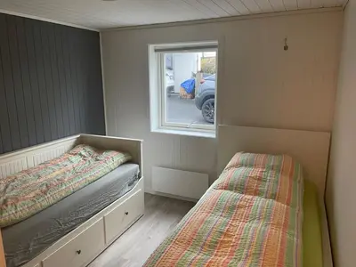 a small bedroom with a bed and a window at Flott leilighet med nydelig utsikt i et stille og rolig boligområde in Bergen