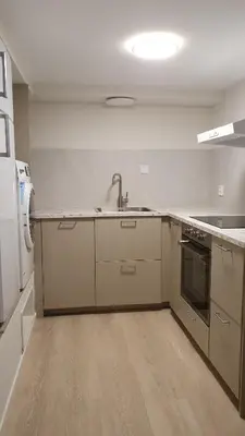 a kitchen with a sink and a refrigerator at Flott leilighet med nydelig utsikt i et stille og rolig boligområde in Bergen