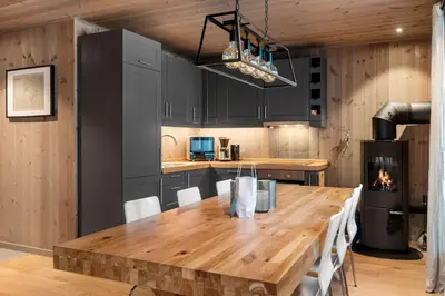 a kitchen with a wooden table and a fireplace at Trysiltunet 28A by Vacation Trysil in Trysil