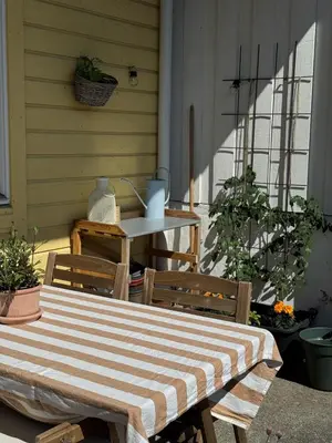 a striped table and chairs on a porch with a table and a tableablish at Charming apartment with balcony and view! in Ålesund