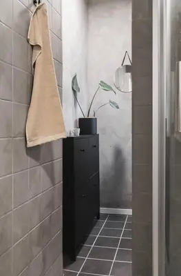 a bathroom with a black cabinet and a potted plant at Cozy apartment in the middle of Bergen city center in Bergen