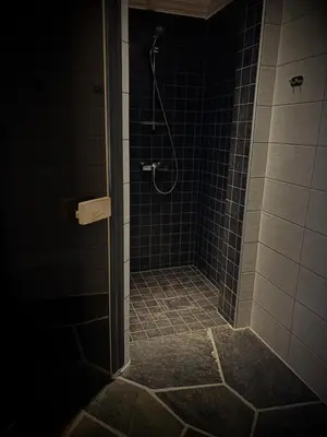 a bathroom with a shower with blue tile at Great mountain cabin with 12 beds in Vågsli