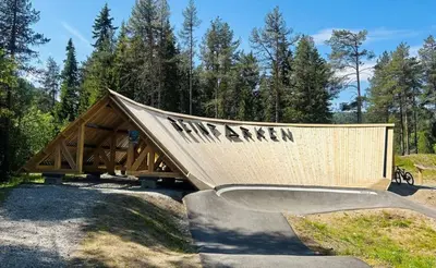 a wooden structure with a skateboard ramp in a park at Great mountain cabin with 12 beds in Vågsli