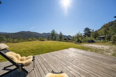 a chair on a deck with a view of a field at Cabin in Hovden with Beautiful views in Bykle