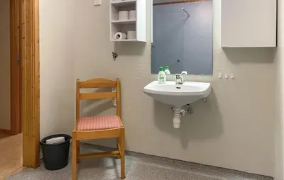 a bathroom with a sink and a chair and a mirror at Amazing Apartment In Verma With Wifi in Verma
