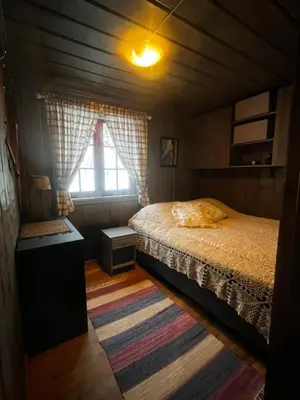 a small bedroom with a bed and a window at The View - Mountain cabin with stunning views in Stranda